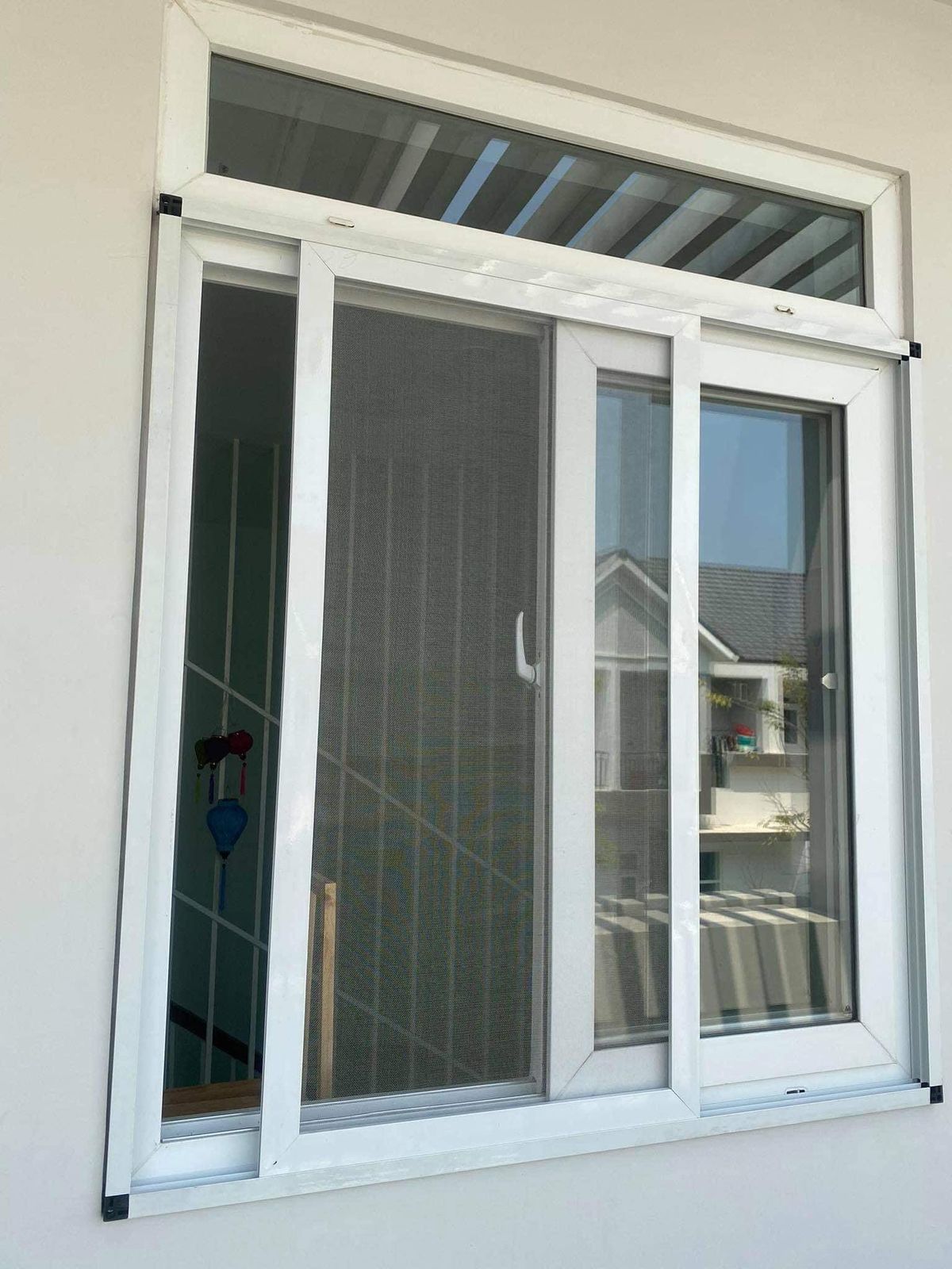 Cửa sổ nhựa trắng lắp cửa lưới chống muỗi dạng lùa, nhìn từ ban công