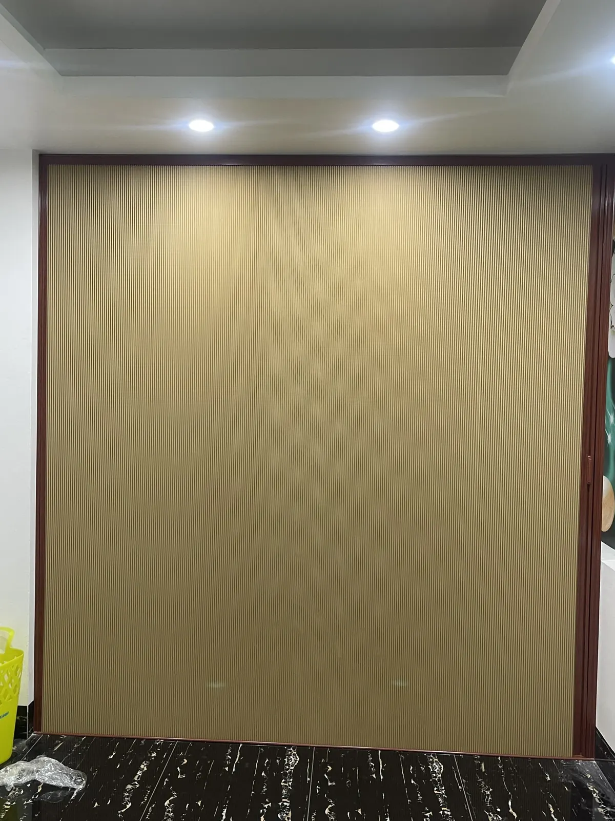 Vách ngăn màu be khung vân gỗ đóng kín một mảng tường lớn