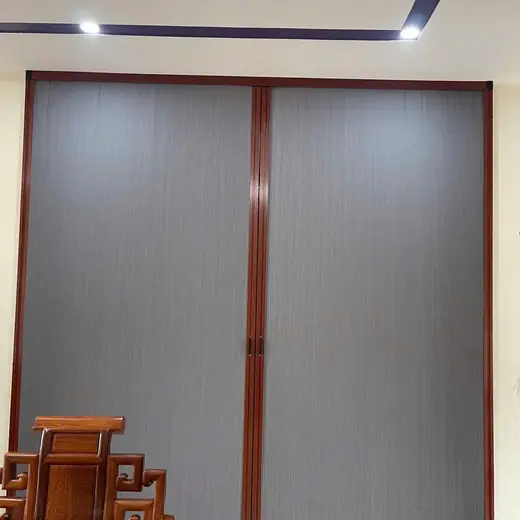 Vách ngăn tổ ong màu ghi, khung nhôm vân gỗ nâu đỏ, cạnh bộ bàn ghế gỗ