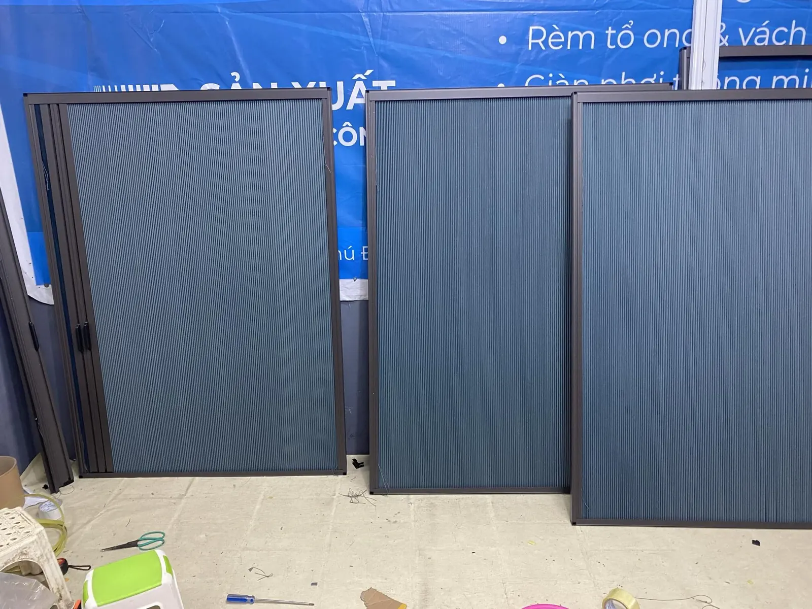 Các tấm vách tổ ong màu xanh than khung đen tại xưởng trước khi giao
